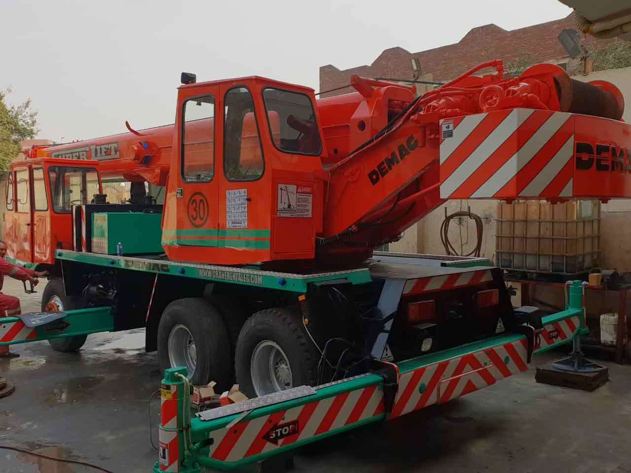 Demag mobile crane with outriggers extended in a rental yard