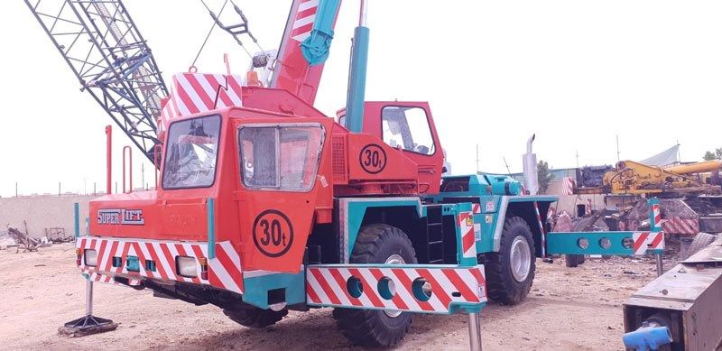 Liebherr mobile crane with outriggers extended in an industrial yard